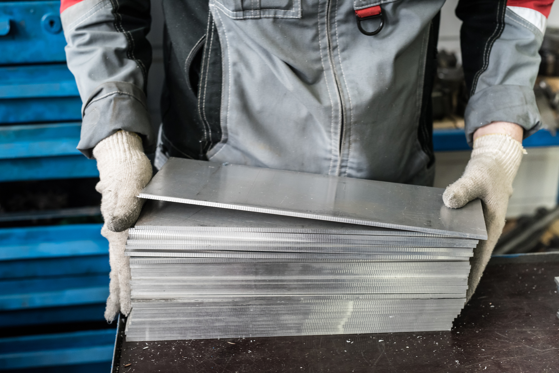 small stack of steel plates on the bench miller, hand in working glovessmall stack of steel plates on the bench miller, hand in working gloves